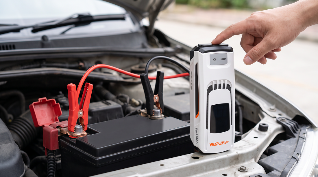 YESPER Fast Max jumpstarter aangesloten op een autoaccu met de rode klem op de pluspool en de zwarte klem op de minpool, terwijl een hand het apparaat bedient